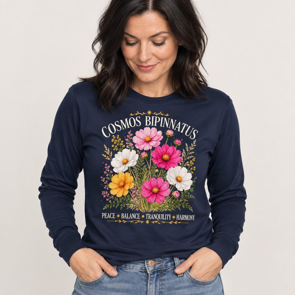 Woman wearing navy Bella Canvas 3501 long sleeve featuring a vintage boho design of realistic cosmos bipinnatus flowers in pink, white, and yellow with ornate gold accents and motivational text, perfect for nature lovers, bohemian, and uplifting fashion, by Crossroads Dandelion