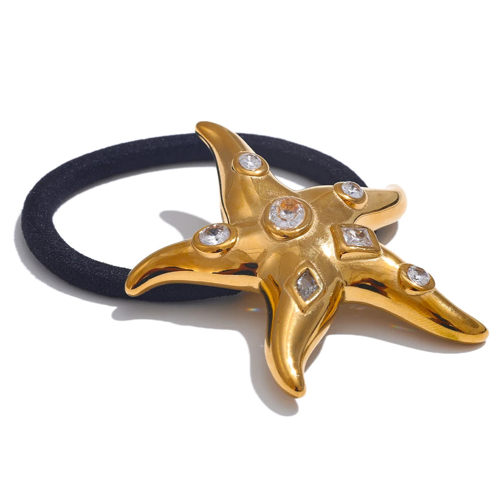 Closeup side view gold star-shaped ponytail hair band with clear gemstones on a white background