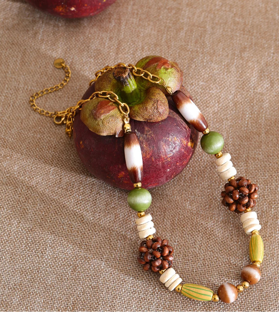 Necklace with natural elements and beads on a textured surface
