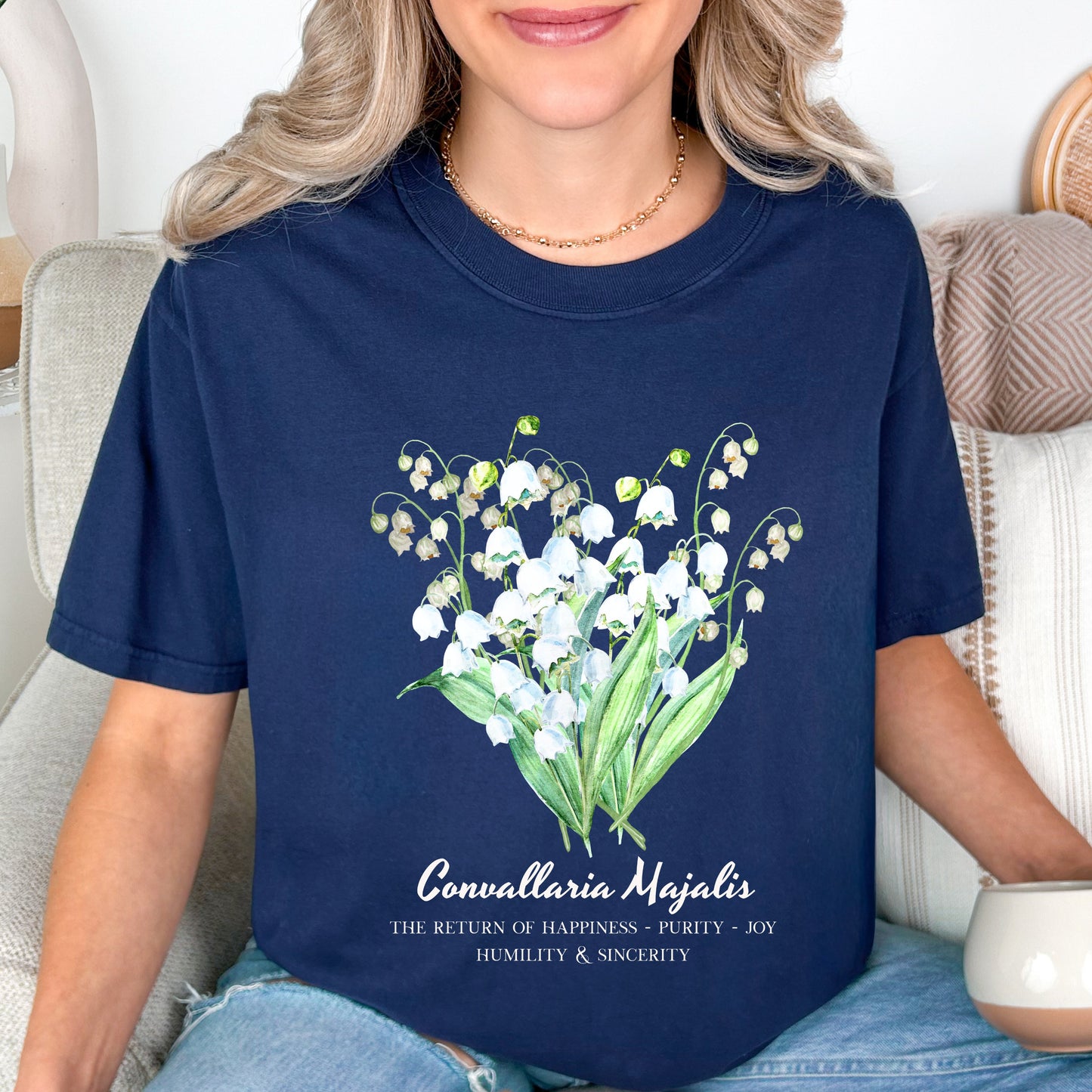 Woman wearing a Navy Convallaria Majalis watercolor botanical tee for May birthdays – Crossroads Dandelion