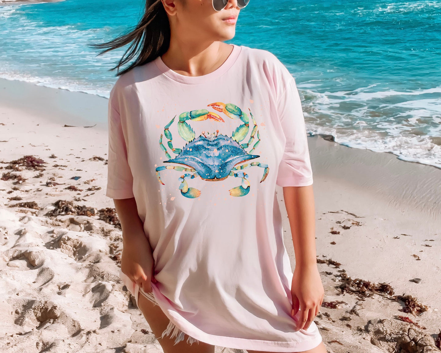 Blue crab watercolor t-shirt in soft pink color with an ocean background by CrossroadsDandelion