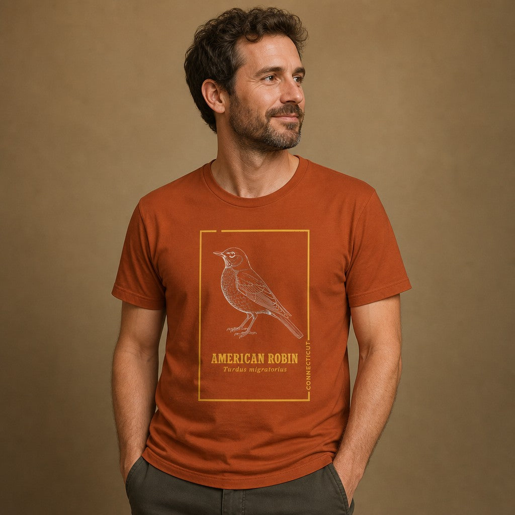 Man in autumn rust Bella Canvas 3001 t-shirt featuring a vintage cottagecore line art of an American Robin, Connecticut state bird, framed with golden botanist trim, ideal for birdwatchers and nature lovers, by Crossroads Dandelion