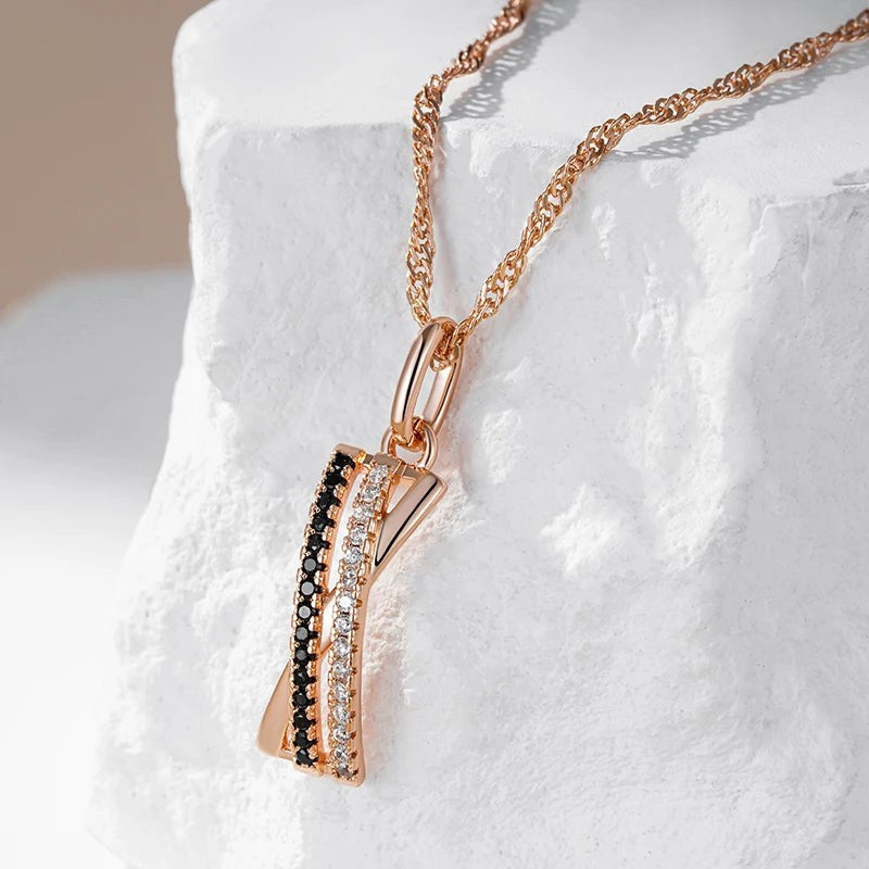 Rose gold criss-cross pendant necklace draped over white stone