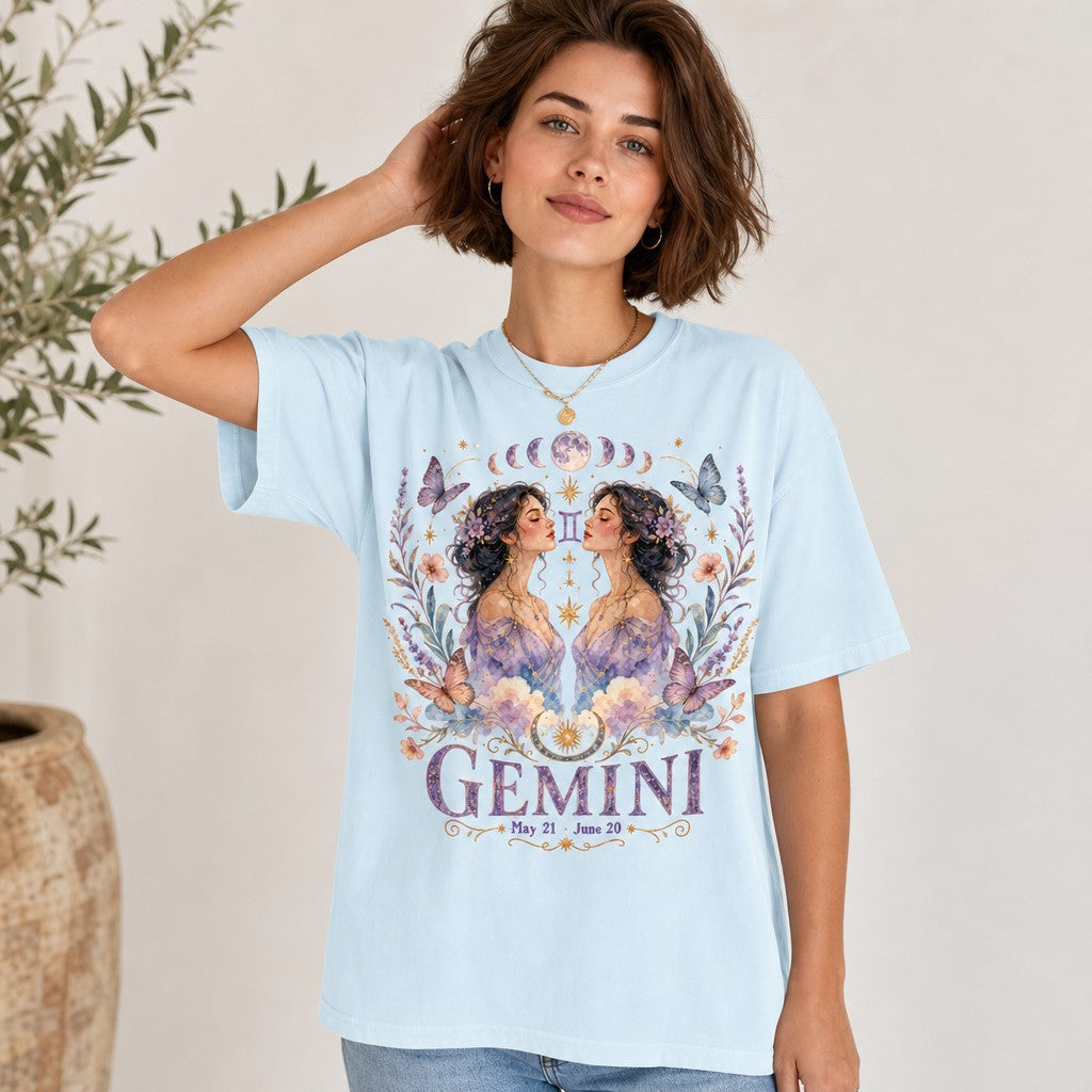 Woman wearing chambray Comfort Colors 1717 t-shirt with watercolor Gemini twin women, celestial moons, butterflies, pastel flowers, dreamy boho astrological design, indoor scene, whimsical zodiac shirt for women, by Crossroads Dandelion