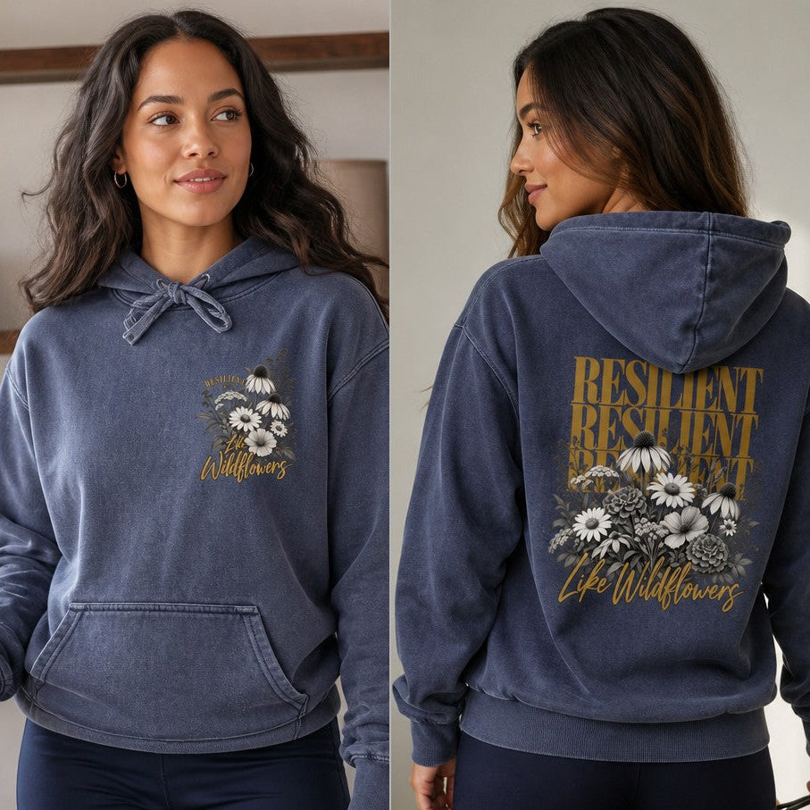 Woman in a denim blue hoodie featuring a vintage wildflower and daisy design with resilient typography, relaxed casual setting, product aimed at women who appreciate inspirational floral prints, by Crossroads Dandelion