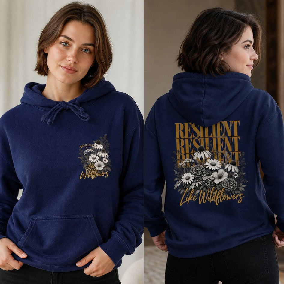 Woman wearing a true navy hoodie with a boho wildflower and resilient script design, botanical motif, floral elements on the front and back, casual indoor setting, apparel for women and floral lovers, by Crossroads Dandelion
