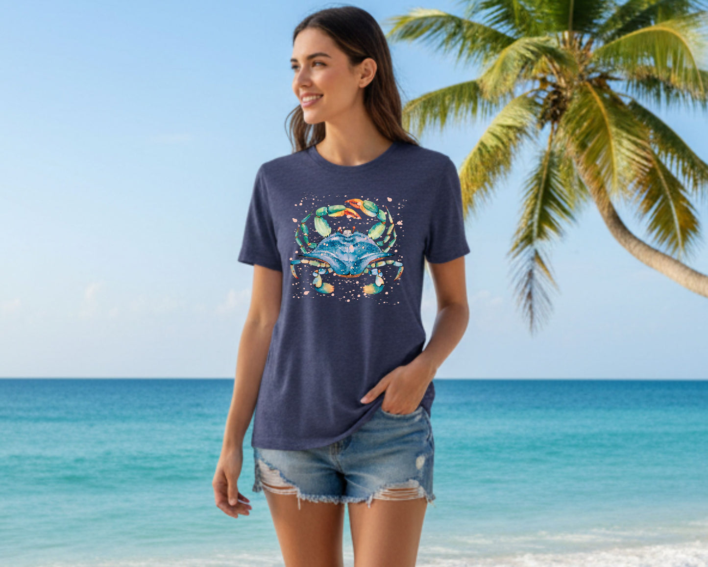 Heather navy ocean lover shirt featuring a woman wearing a watercolor blue crab artwork in the beach