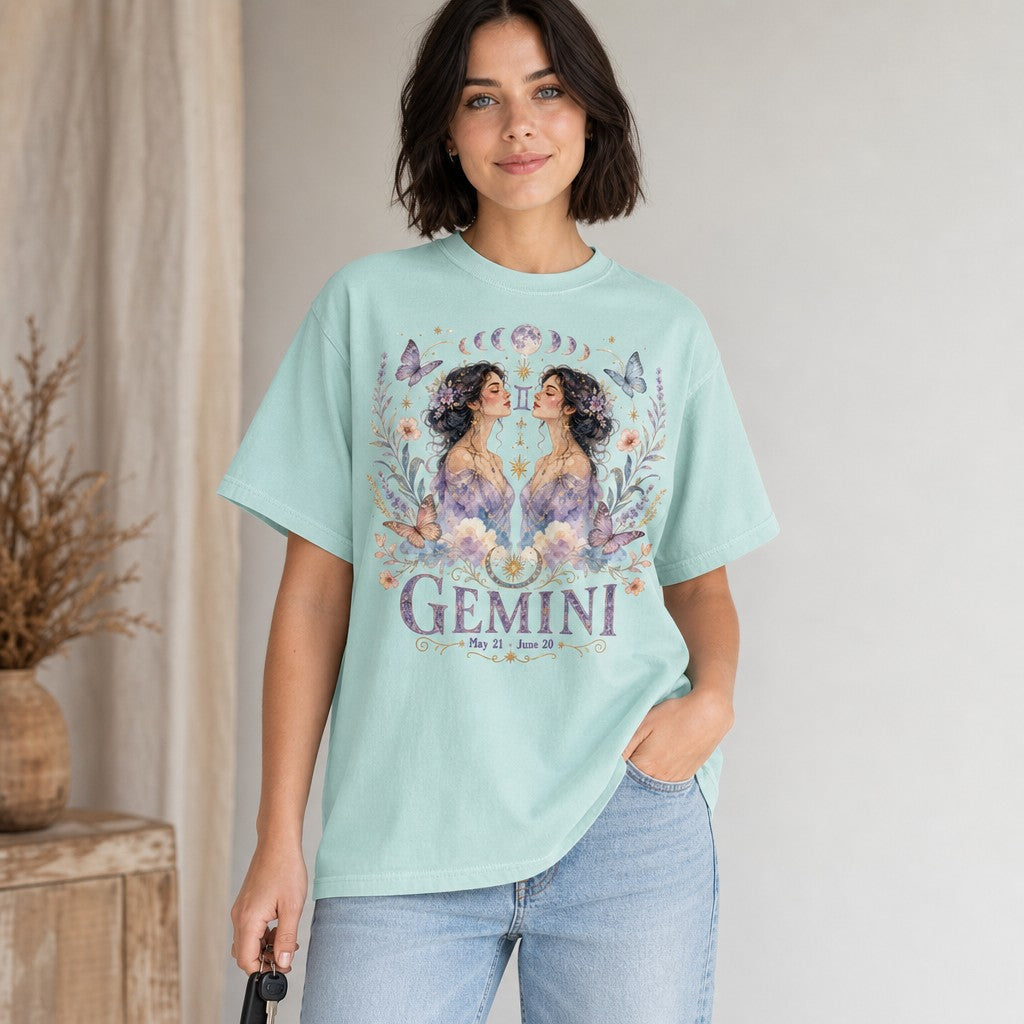 Woman wearing a chalky mint Comfort Colors 1717 t-shirt with a whimsical boho Gemini design featuring watercolor twin women, celestial jewelry, pastel butterflies, florals, and moon phases, perfect for astrology and zodiac lovers, by Crossroads Dandelion