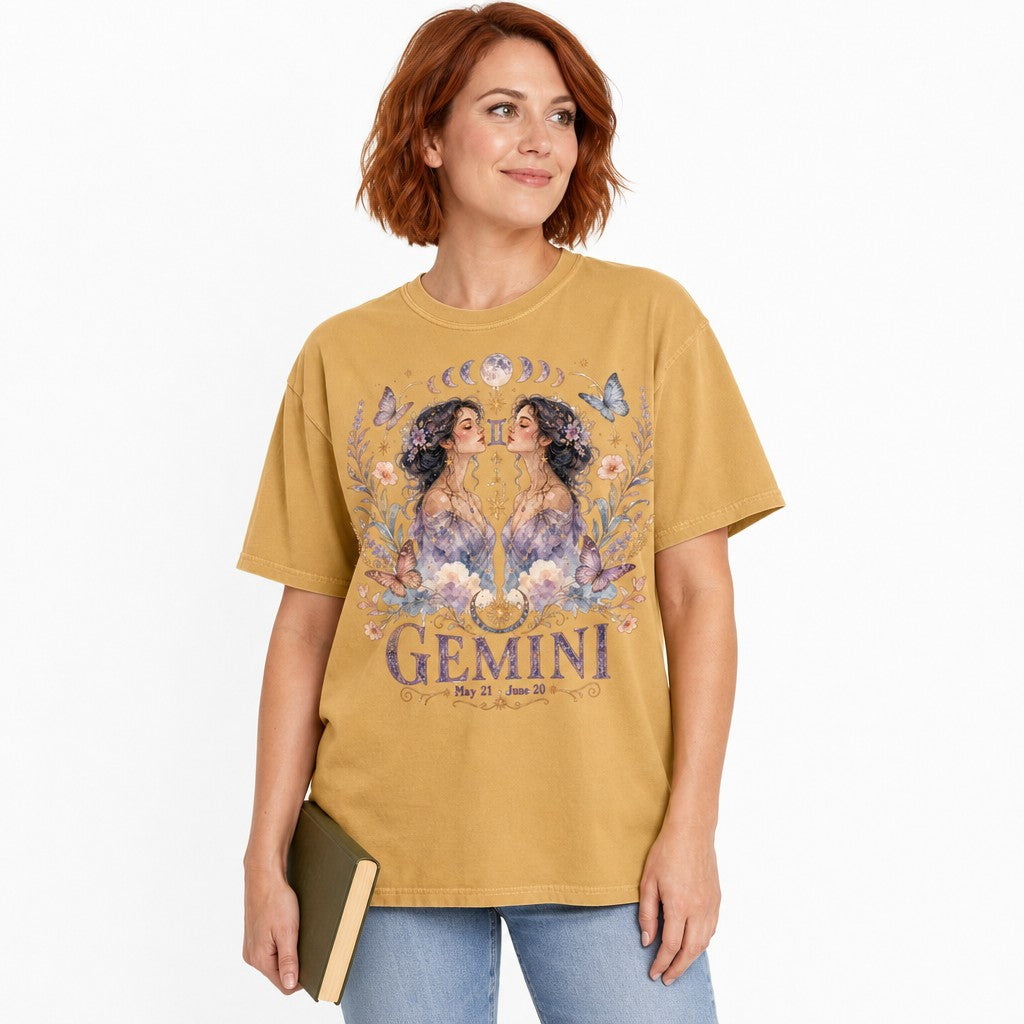 Woman wearing a mustard Comfort Colors 1717 t-shirt with a whimsical boho Gemini design featuring watercolor twin women, celestial jewelry, butterflies, flowers, and moon phases, perfect zodiac gift for women, by Crossroads Dandelion