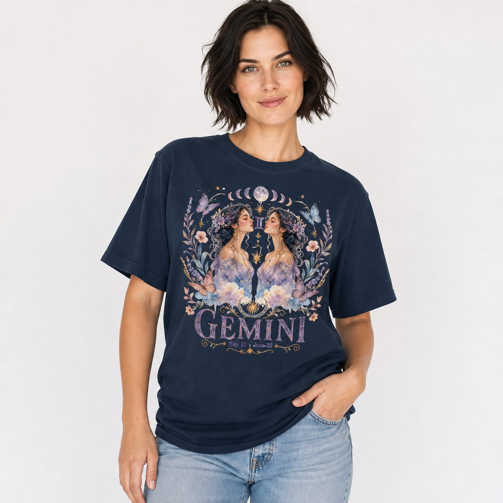 Woman wearing a navy Comfort Colors 1717 t-shirt featuring a whimsical boho Gemini design with watercolor twin women, celestial jewelry, pastel butterflies, flowers, and moon phases, perfect for astrology lovers and dreamy style enthusiasts, by Crossroads Dandelion