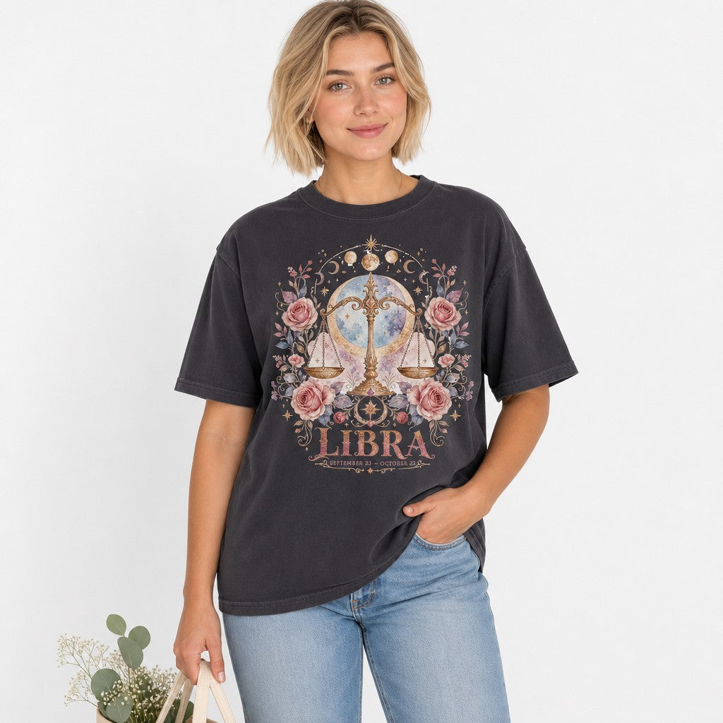 Woman wearing a pepper Comfort Colors 1717 t-shirt featuring a watercolor boho Libra scales illustration with pink roses, golden stars, cosmic celestial accents, ideal for astrology and zodiac lovers, by Crossroads Dandelion