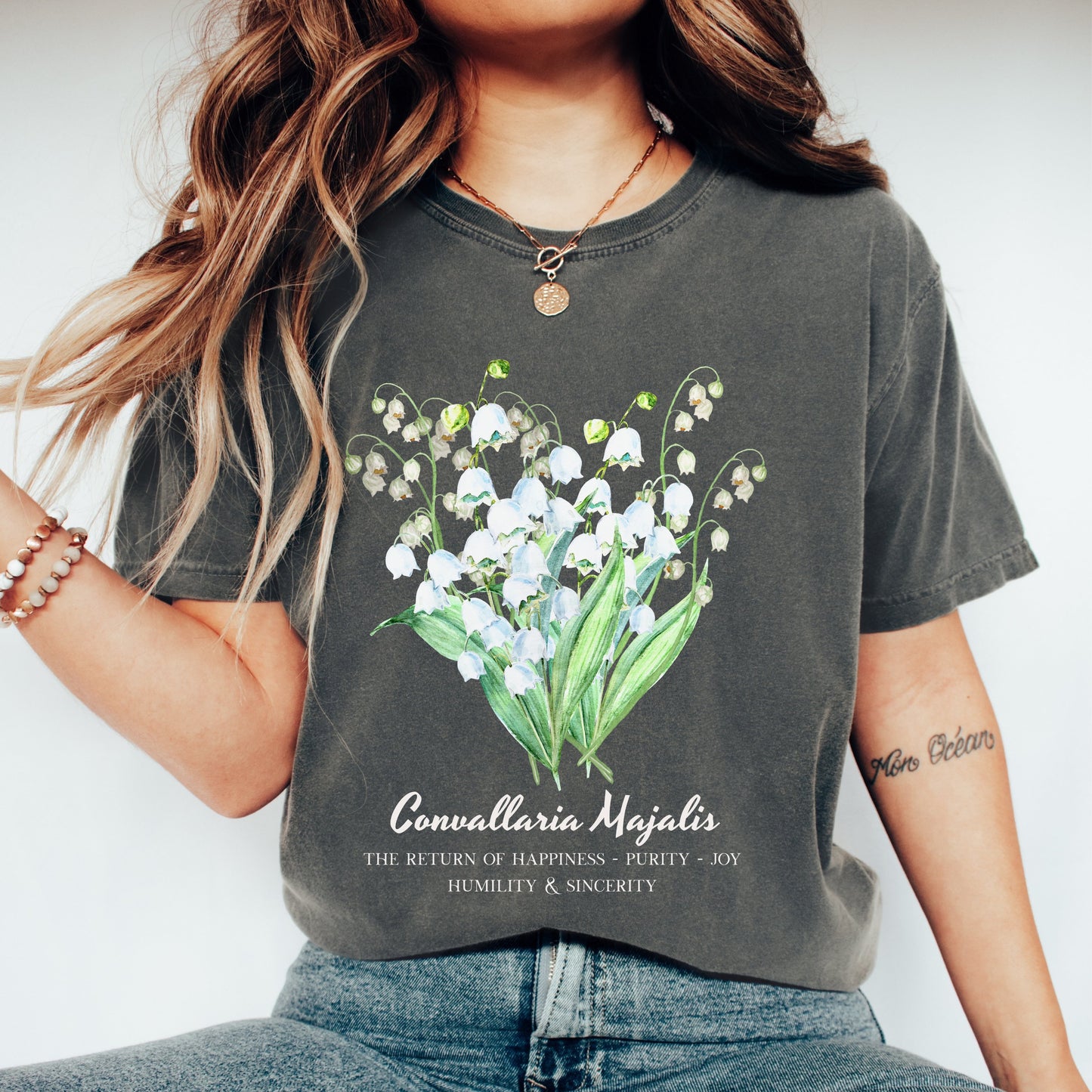 Woman wearing a Pepper garment-dyed Convallaria Majalis botanical tee – Crossroads Dandelion