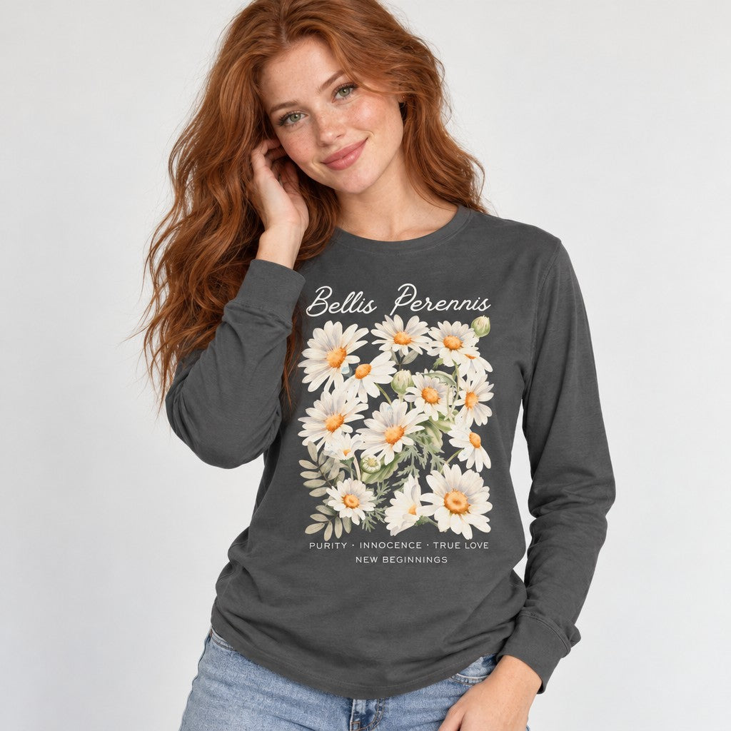 Woman wearing an asphalt Bella Canvas 3501 long sleeve shirt featuring a soft watercolor Bellis perennis daisy bouquet with lavender-blue petals, golden-yellow centers, and delicate calligraphy, cottagecore floral design for romantic souls, brides, and flower lovers, by Crossroads Dandelion