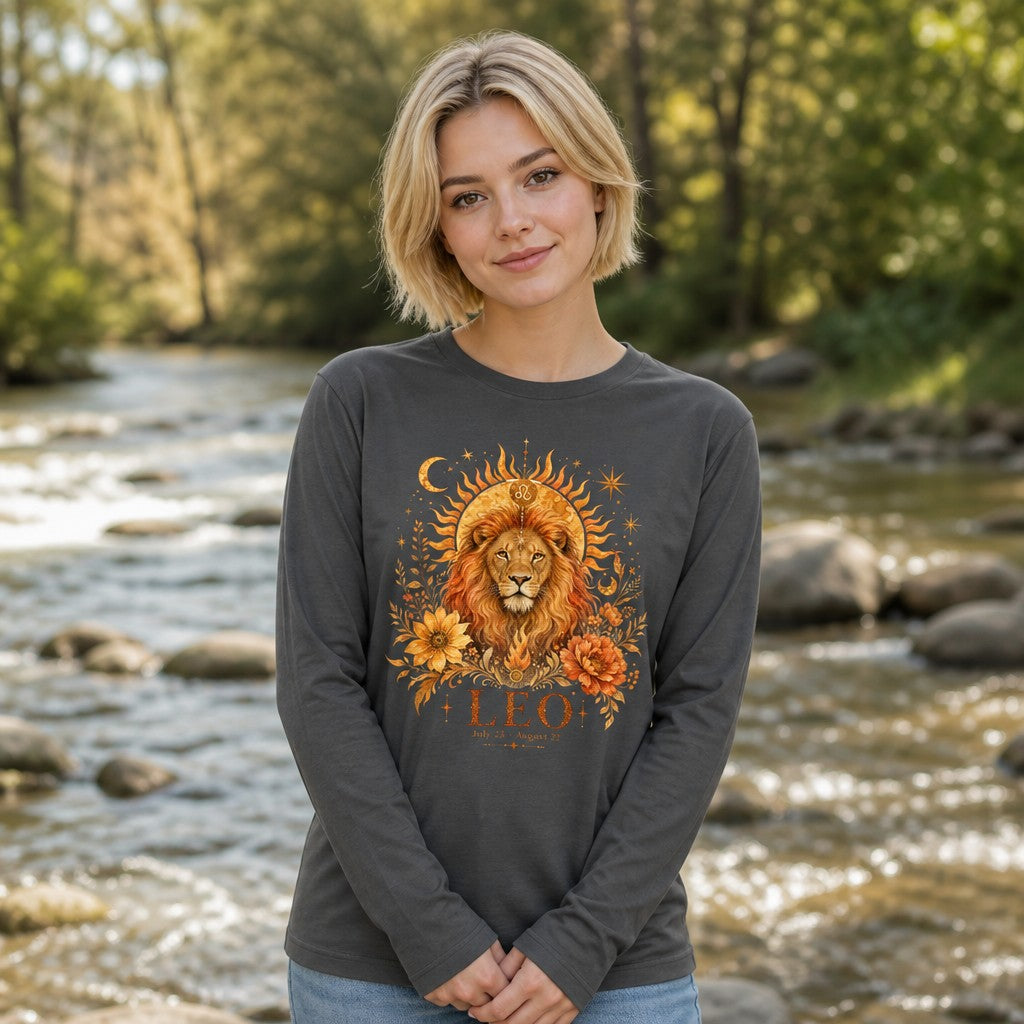 Woman in an asphalt Bella Canvas 3501 long sleeve showcasing a cottagecore Leo lion zodiac design, hand-painted with golden sunbeams, moons, stars, and lush florals, standing by a river, ideal for astrology and botanical art lovers, by Crossroads Dandelion