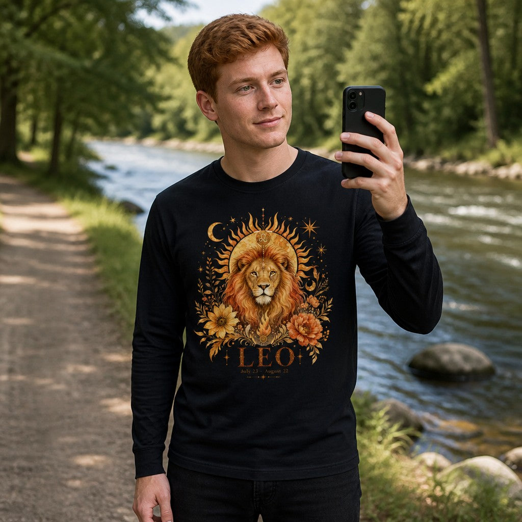 Man in black Bella Canvas 3501 long sleeve featuring a cottagecore regal lion Leo zodiac design with golden sunbeams, crescent moons, stars, and botanical florals, standing by a riverside, perfect for astrology and star sign lovers, by Crossroads Dandelion