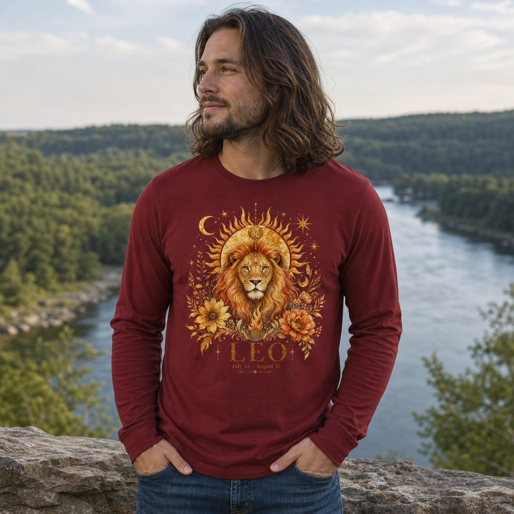Man wearing a cardinal Bella Canvas 3501 long sleeve shirt with a hand-painted cottagecore Leo lion zodiac design, surrounded by golden sunbeams, moons, stars, and lush florals, standing outdoors by a scenic river, perfect for astrology lovers and nature enthusiasts, by Crossroads Dandelion