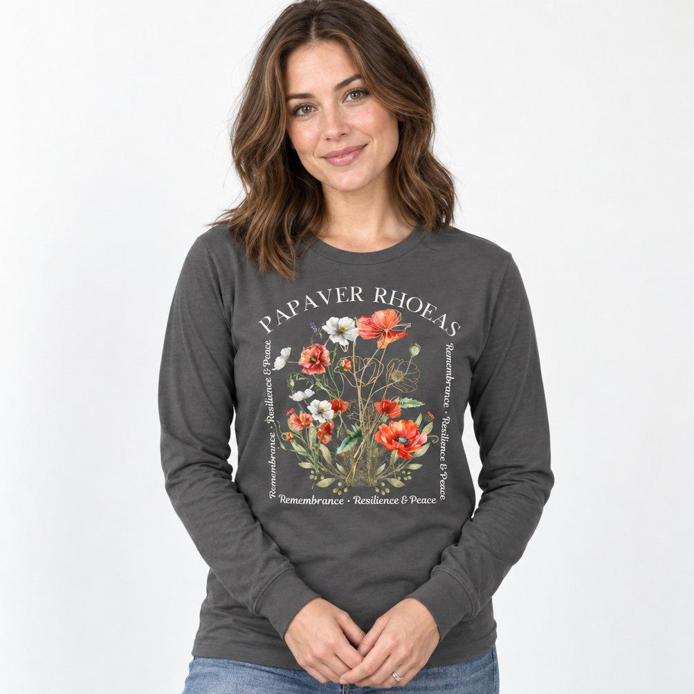 Woman wearing an asphalt Bella Canvas 3501 long sleeve shirt featuring a cottagecore watercolor design of lush red, white, and blush poppies with golden botanical accents and poetic text, perfect for nature lovers and artful souls, by Crossroads Dandelion