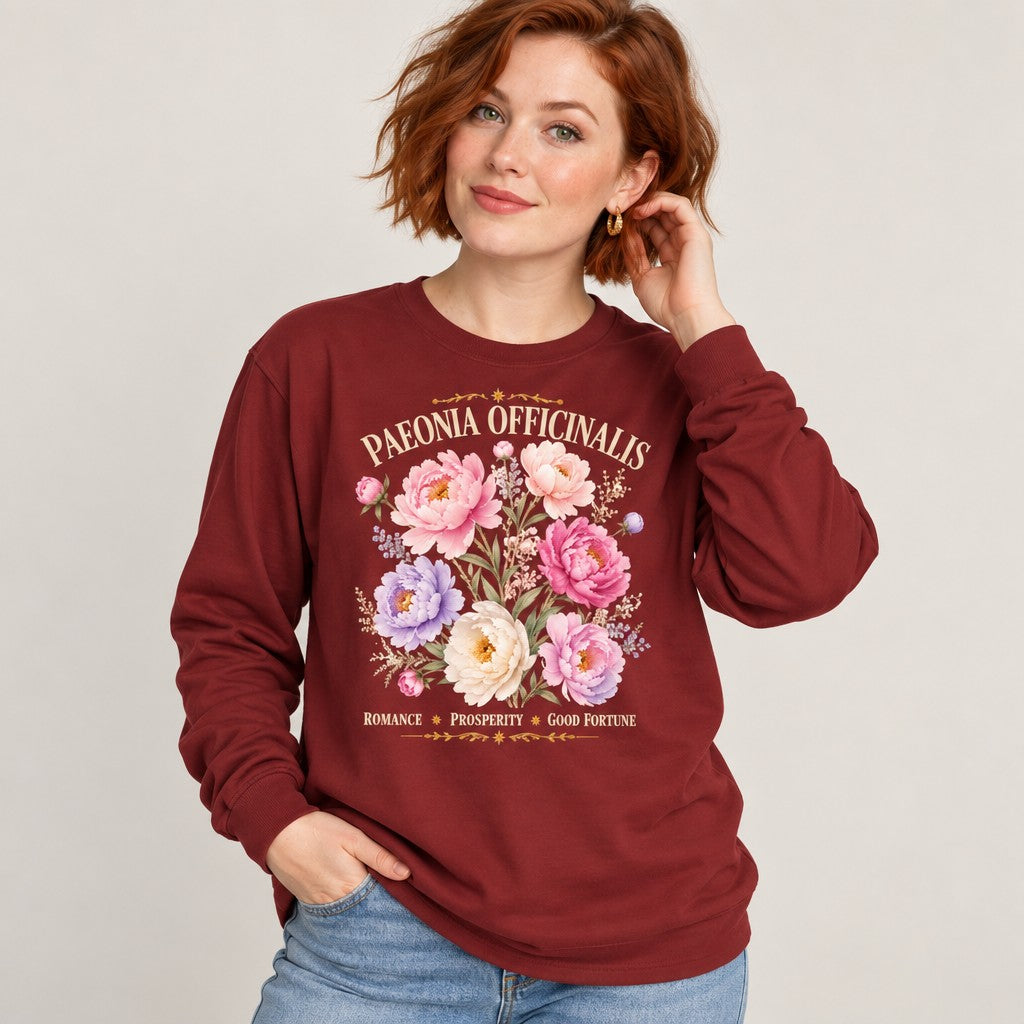 Woman in a cardinal red long sleeve Bella Canvas shirt featuring romantic watercolor peony illustration with vintage botanical script, cottagecore floral pressed flower design, perfect for garden and botanical enthusiasts, by Crossroads Dandelion