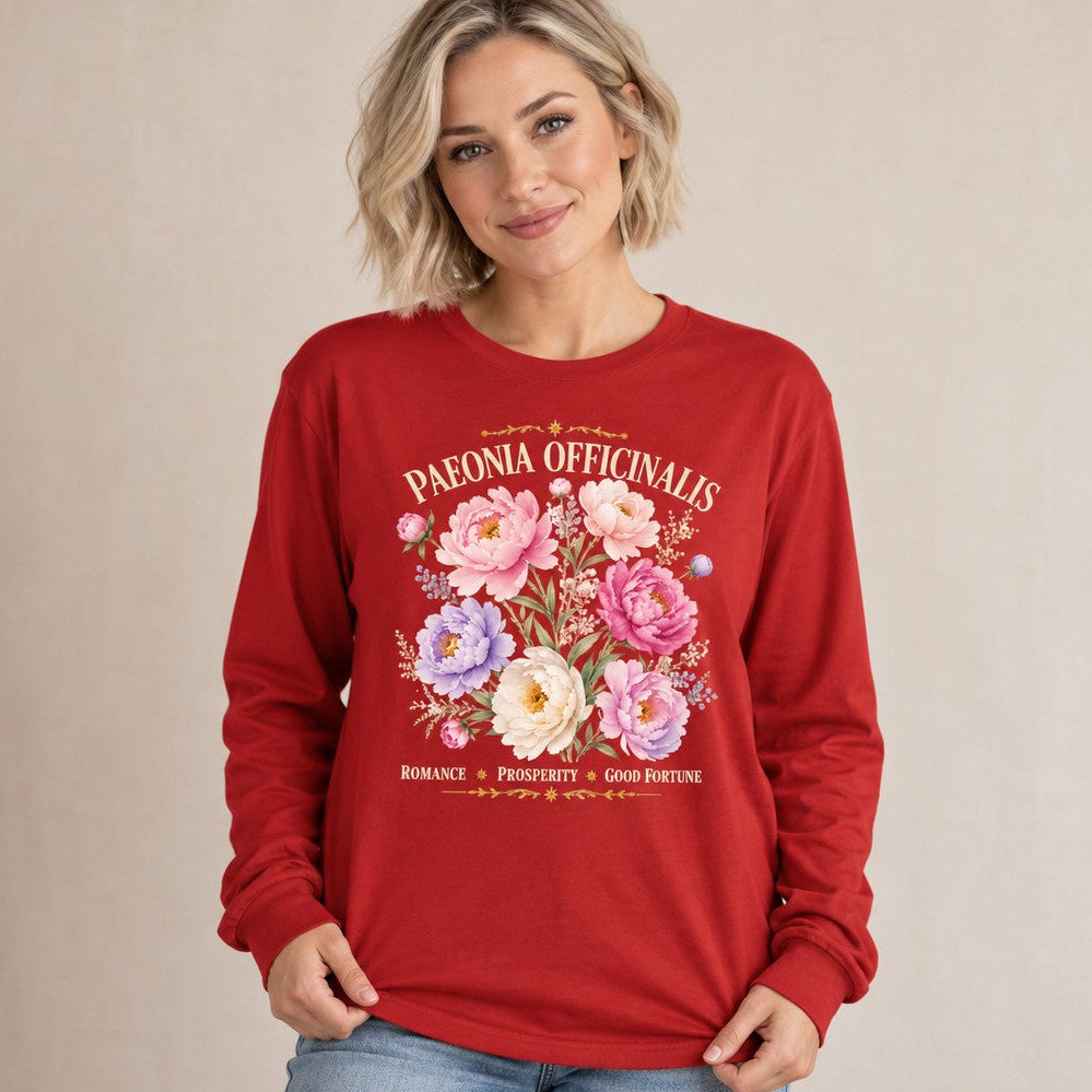 Woman wearing a red Bella Canvas 3501 long sleeve shirt featuring a romantic watercolor peony and wildflower botanical print with vintage script, cottagecore feminine garden-inspired floral design, perfect for botanical lovers and cottagecore enthusiasts, by Crossroads Dandelion