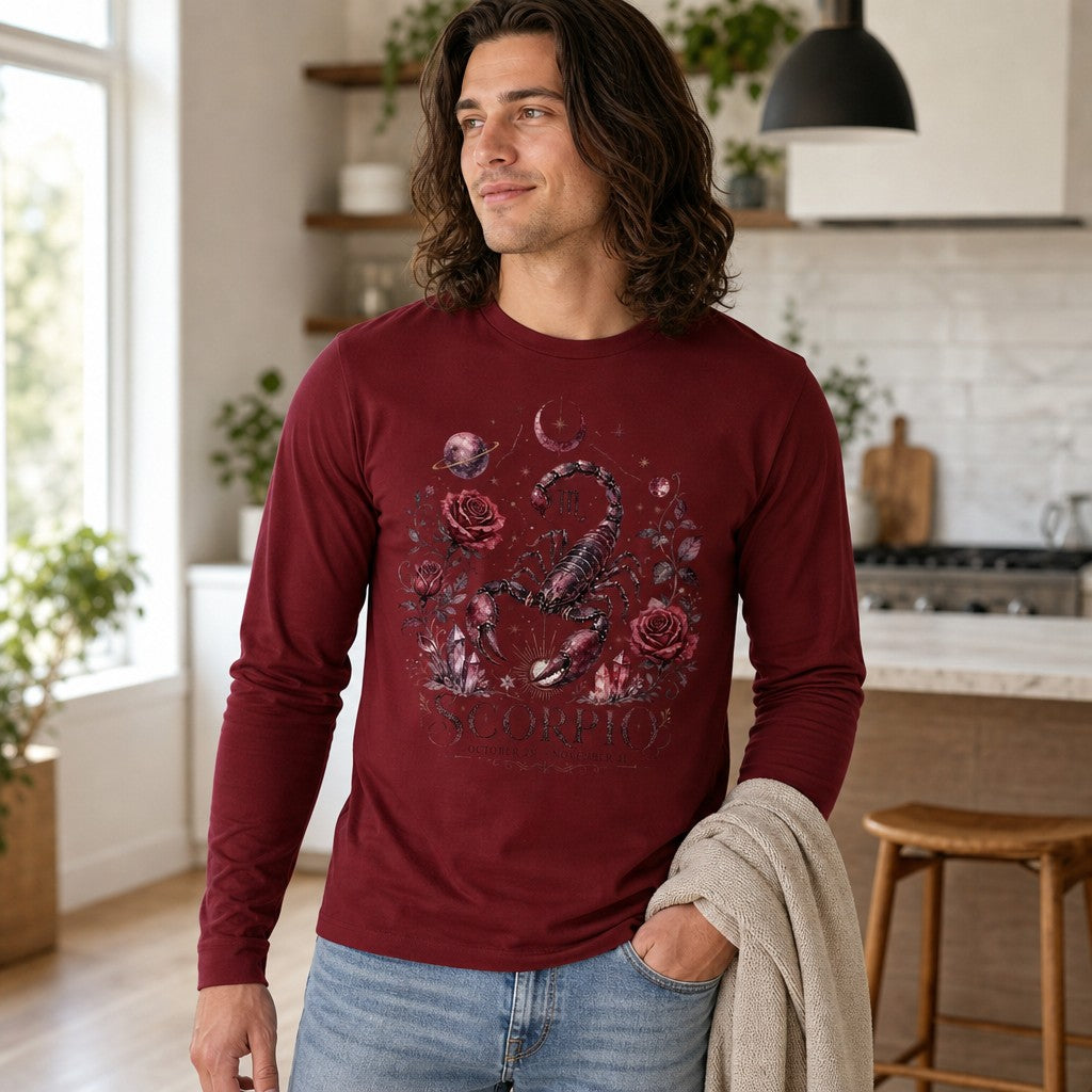 Man wearing a cardinal red Bella Canvas 3501 long sleeve shirt featuring a hand-painted Scorpio scorpion with vintage botanical roses, amethyst crystals, moons, and planetary celestial details in a mystical cottagecore style, perfect for astrology lovers, photographed in a bright kitchen setting, by Crossroads Dandelion