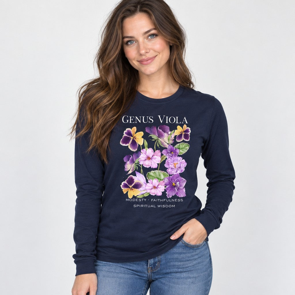 Woman wearing a navy Bella Canvas 3501 long sleeve shirt with a cottagecore watercolor bouquet of violets and pansies, botanical symbolism for modesty, faithfulness, and spiritual wisdom, vintage nature journal style, ideal for botanical art lovers and women, by Crossroads Dandelion