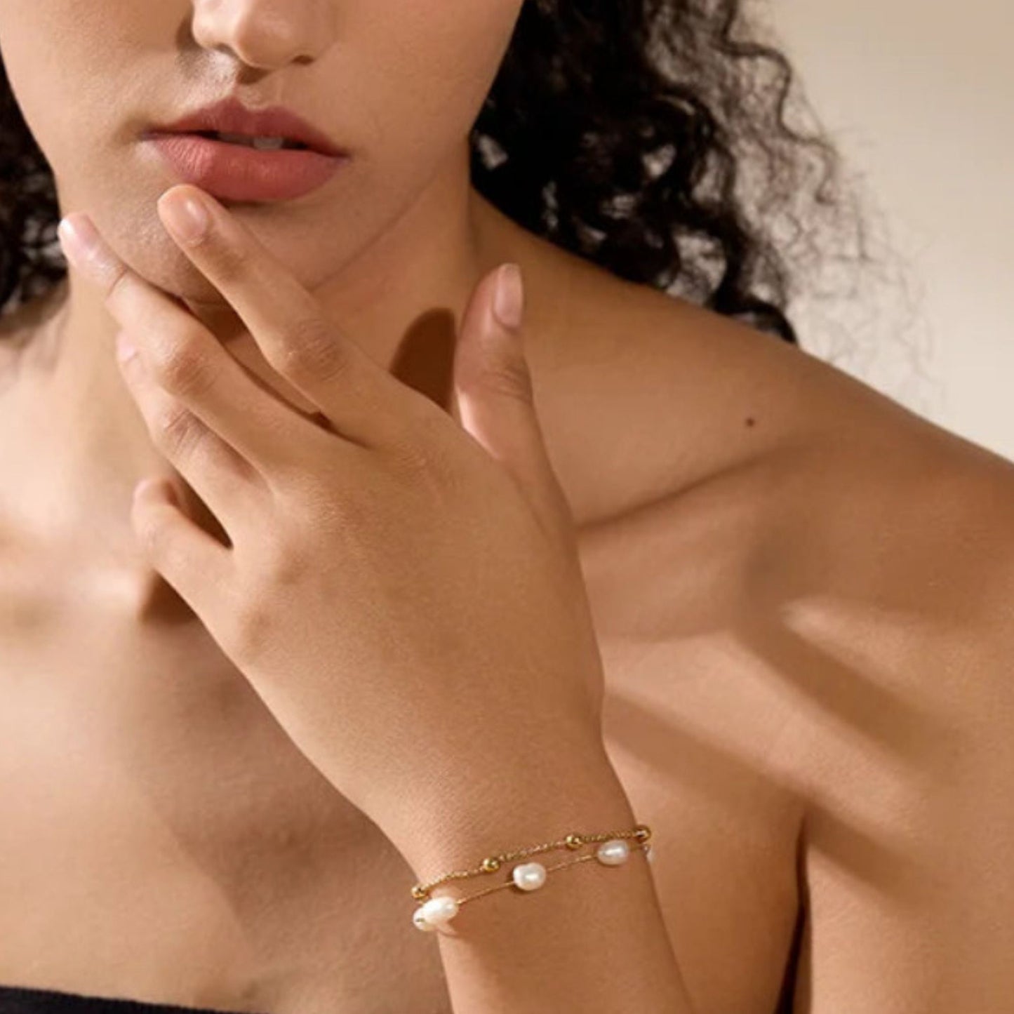 Woman wearing double layer natural pearl gold bracelet on wrist, lifestyle closeup by Crossroads Dandelion