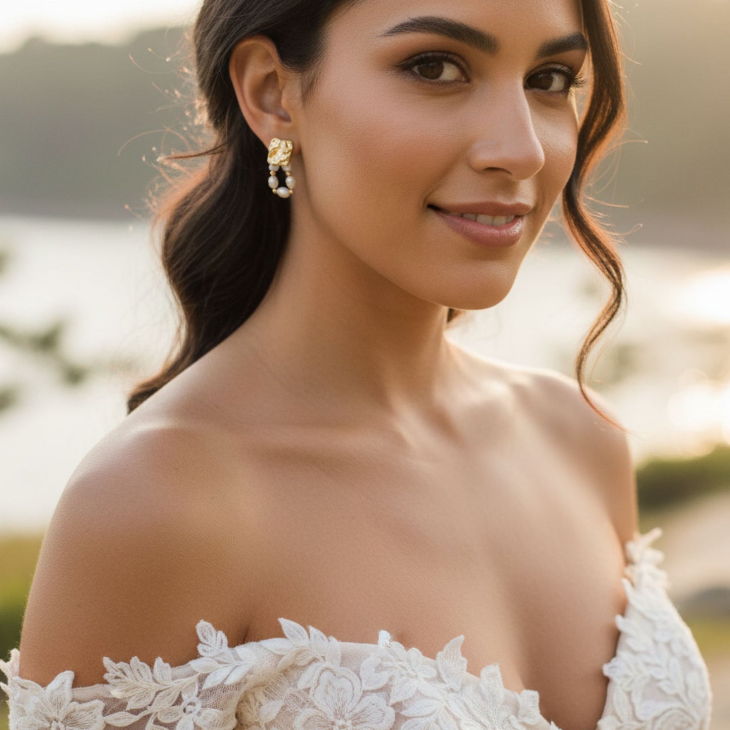 Freshwater baroque pearl drop earrings in gold plated stainless steel worn by bride in off-shoulder lace wedding gown at golden hour outdoor setting, by Crossroads Dandelion