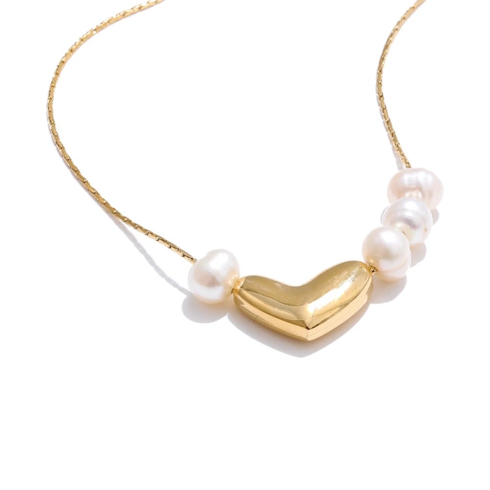 Gold puffy heart necklace with freshwater pearls on a fine chain, front view on white