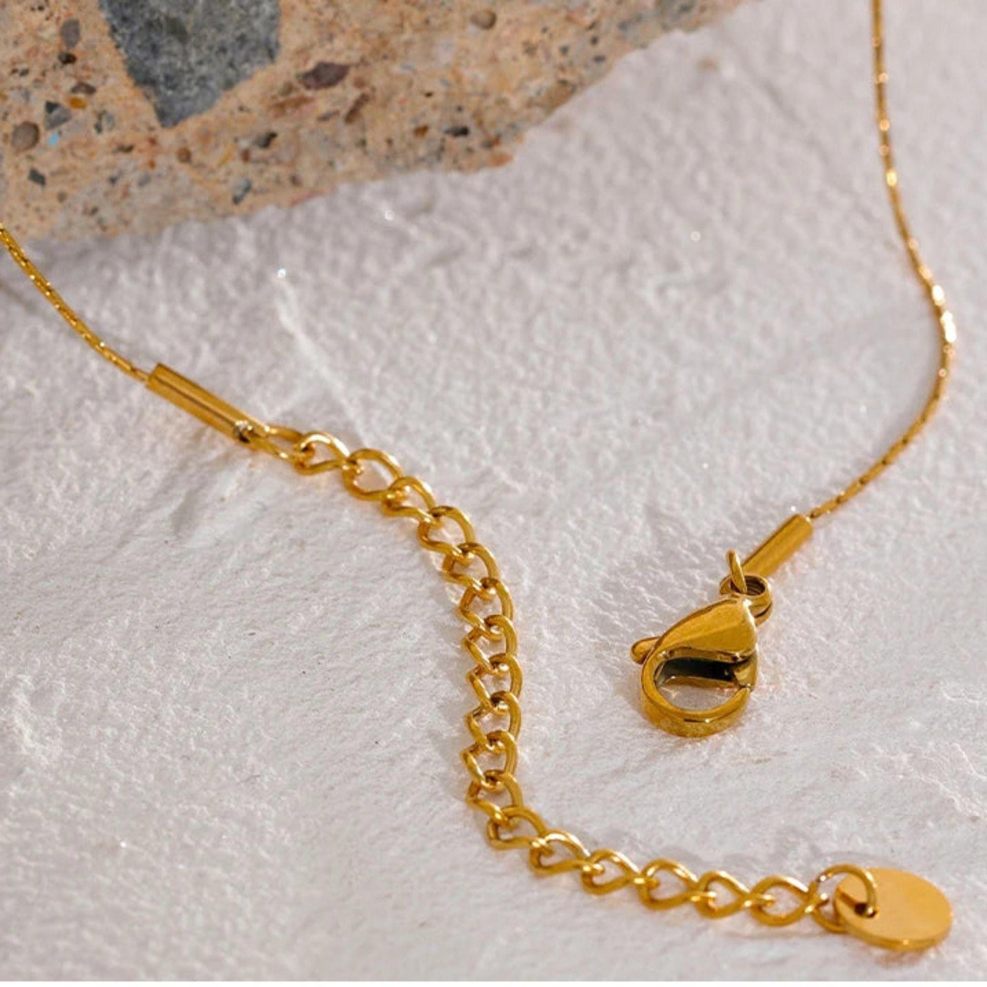Close - up of the Gold chain necklace clasp and adjustable extender detail