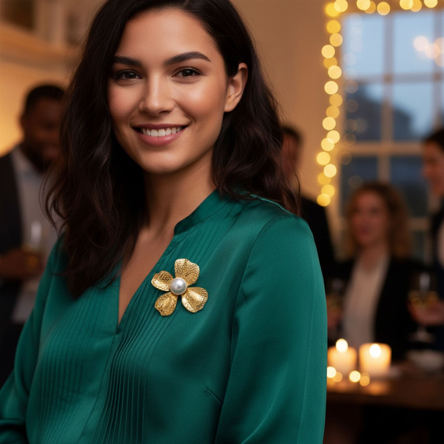 Woman wearing a green dress with a gold brooch in a festive indoor setting