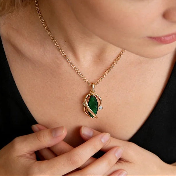 Woman in a black top wearing the green leaf pendant necklace in rose gold