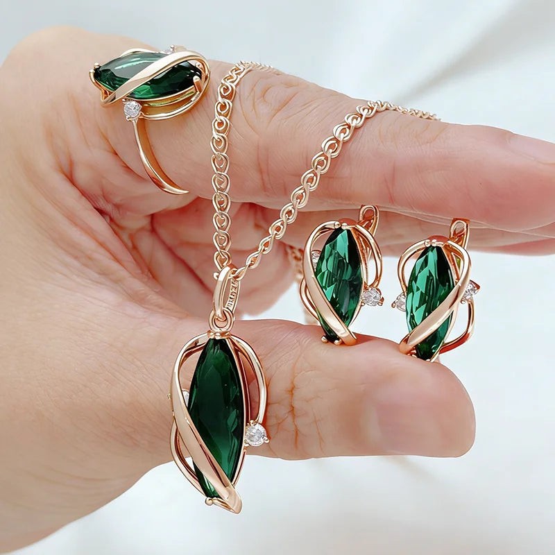 Green leaf pendant, earrings and ring in rose-gold frames held in an open hand