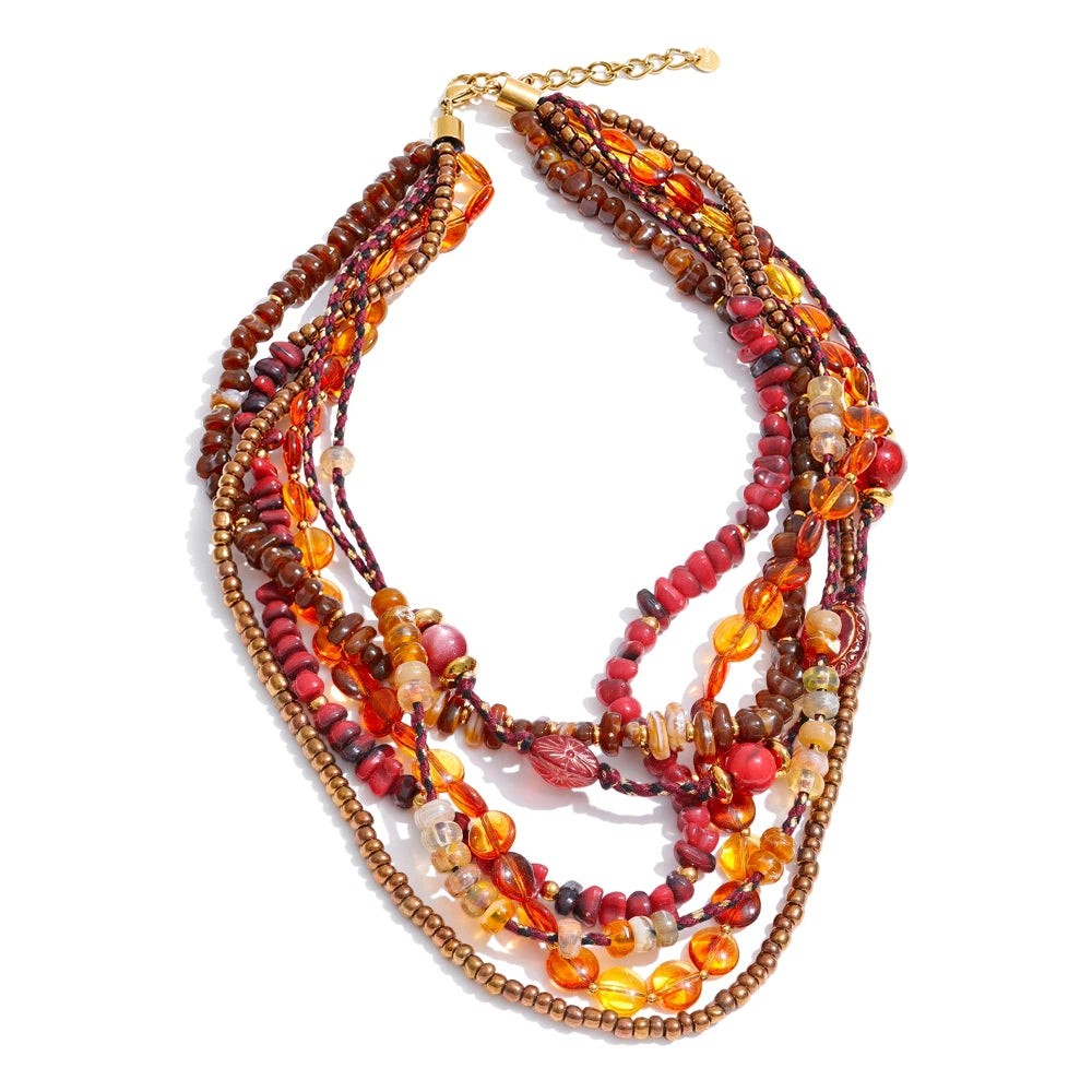 Amber, red and brown layered beaded bib necklace with a gold extension chain on white