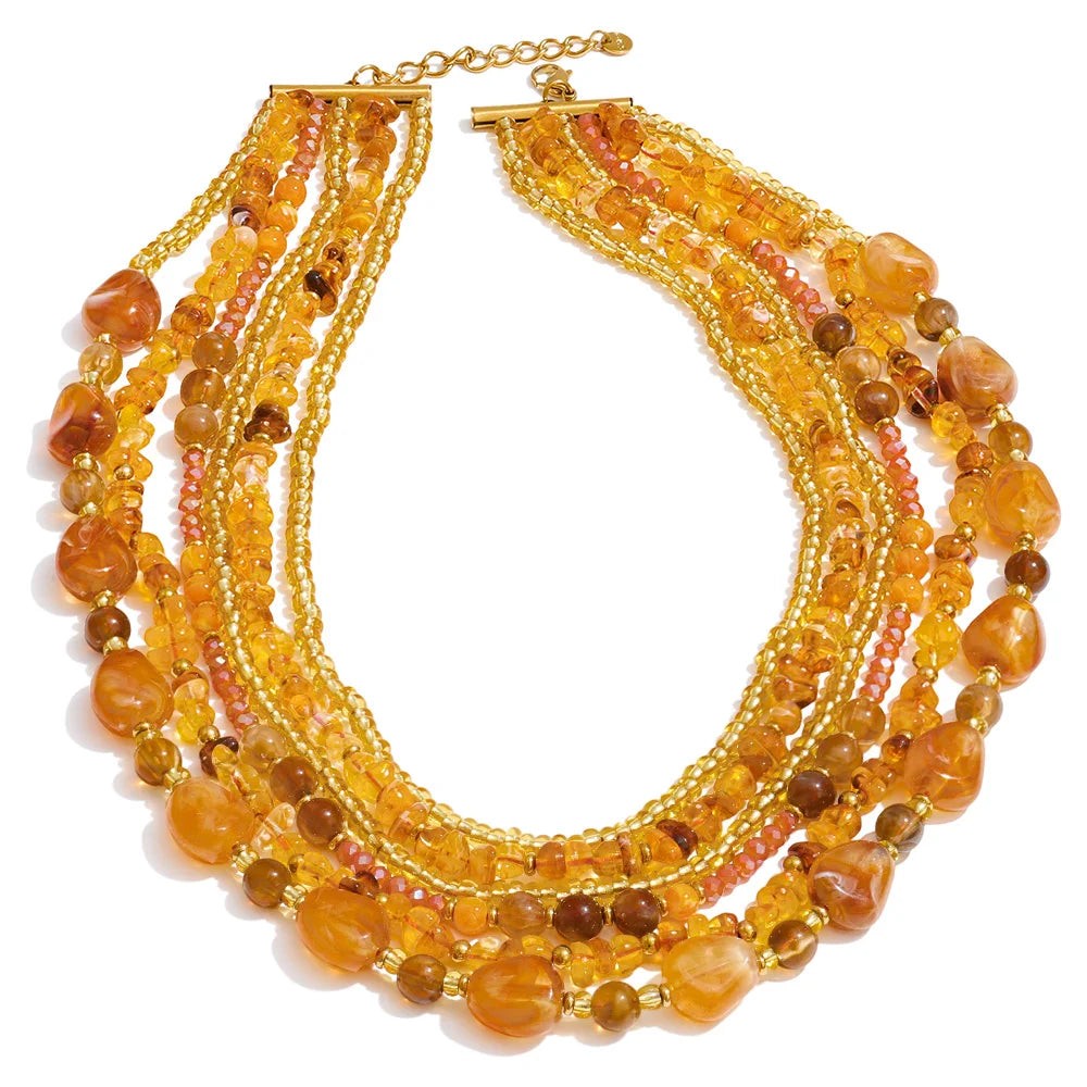 Honey and golden layered beaded bib necklace with gold-plated ends, laid flat on white