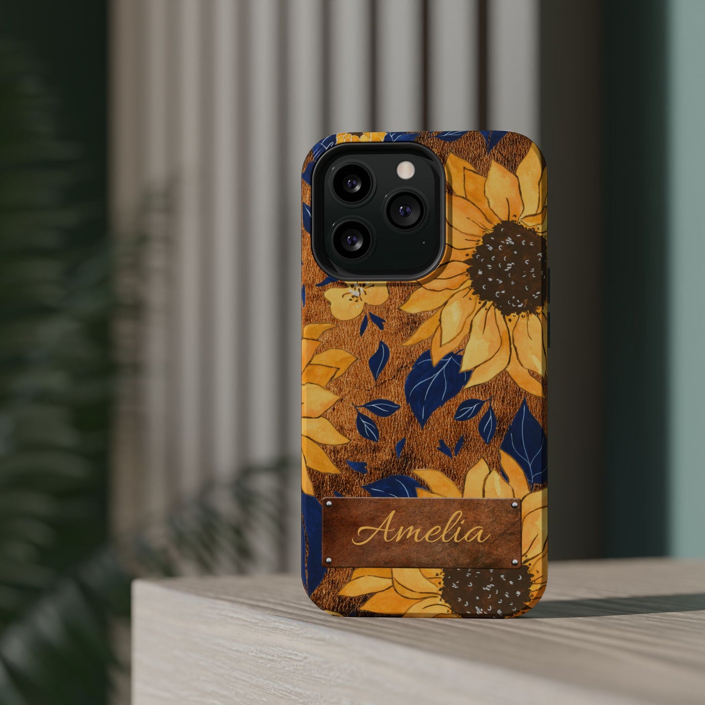 Custom name personalized sunflower western tough phone case for iPhone 13 Pro, featuring bold yellow sunflowers, navy blue leaves, rustic brown faux leather texture background, and a riveted metal name plate — perfect boho cowgirl gift, by Crossroads Dandelion