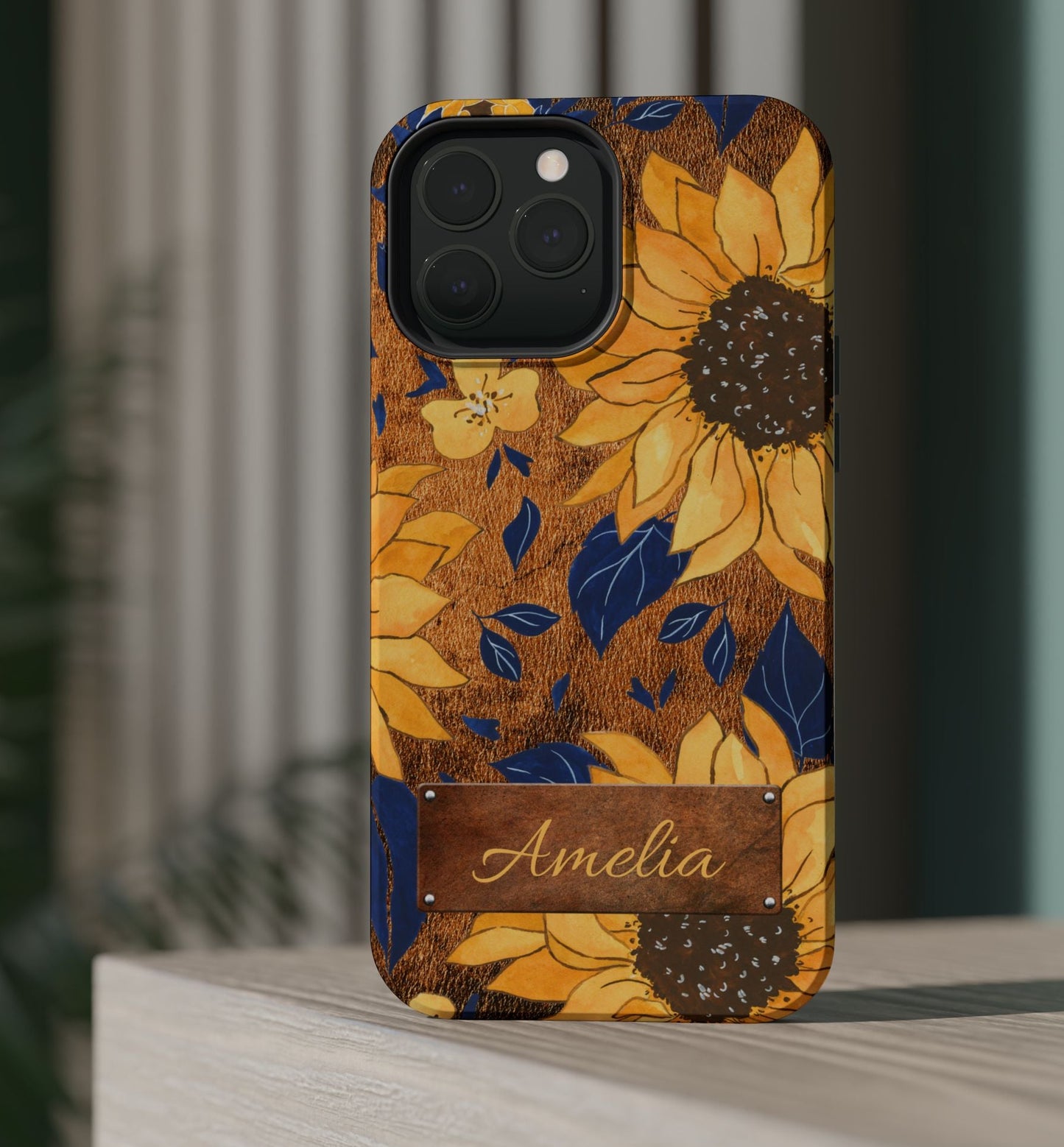Custom name personalized sunflower western tough phone case for iPhone 13 Pro Max, featuring bold yellow sunflowers, navy blue leaves, rustic brown faux leather texture background, and a riveted metal name plate — perfect boho cowgirl gift, by Crossroads Dandelion