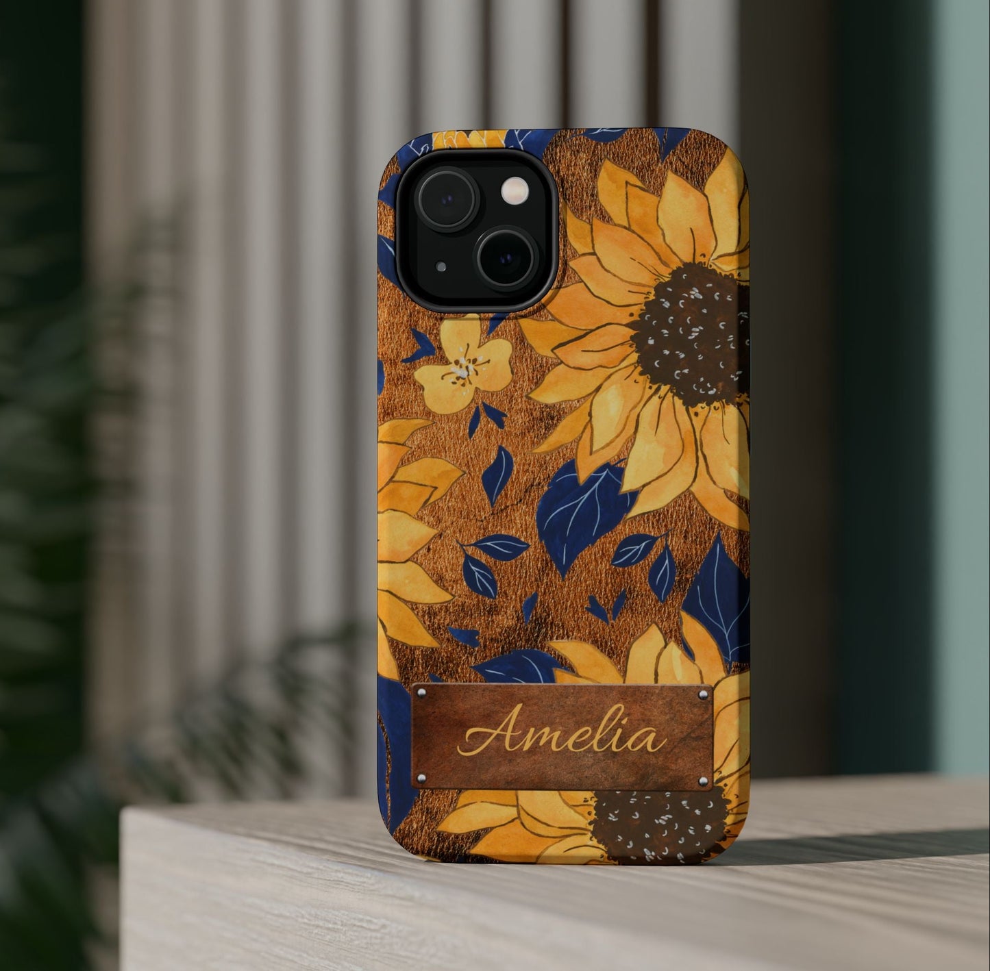 Custom name personalized sunflower western tough phone case for iPhone 14, featuring bold yellow sunflowers, navy blue leaves, rustic brown faux leather texture background, and a riveted metal name plate — perfect boho cowgirl gift, by Crossroads Dandelion