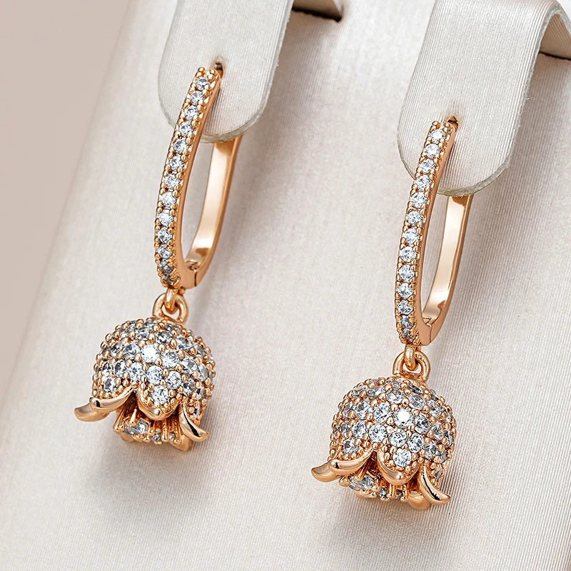 Lily of the valley drop earrings hanging from a cream satin jewelry display