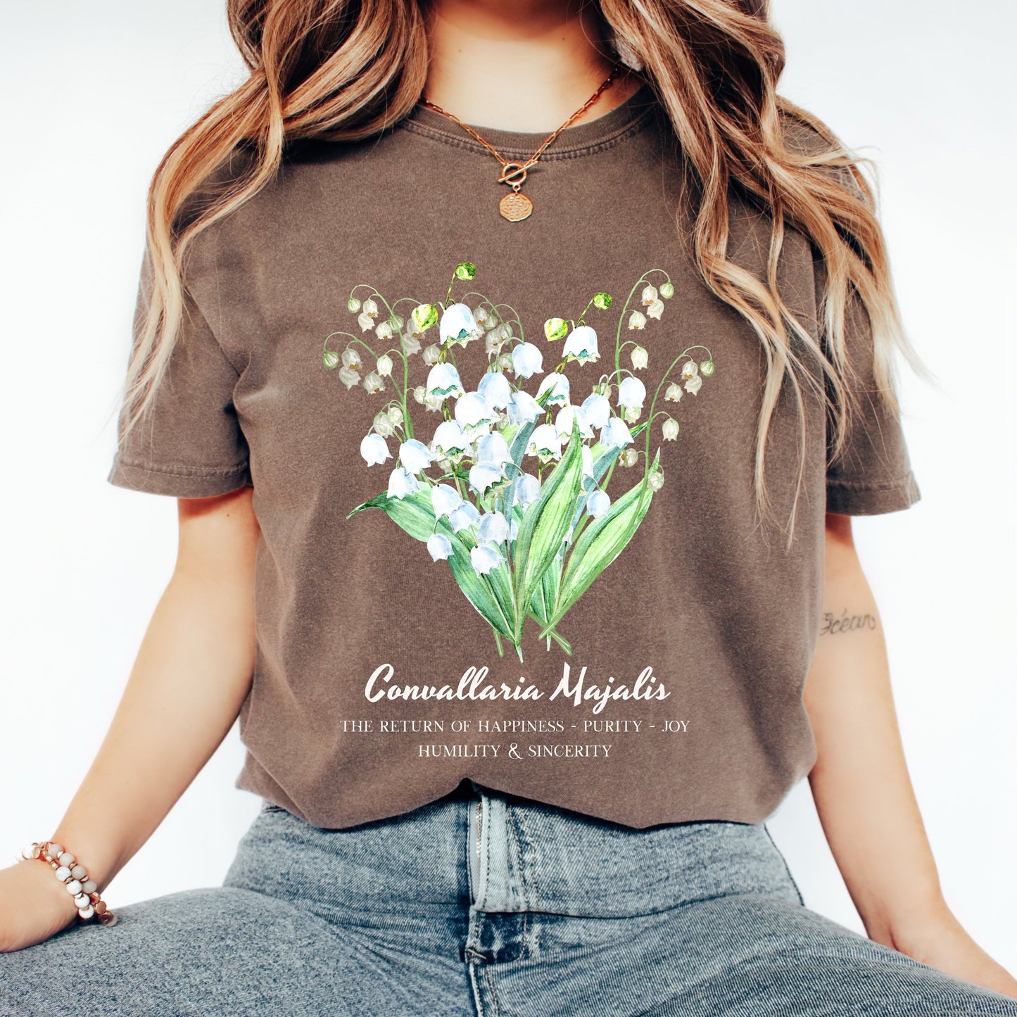 Woman wearing an Espresso brown Lily of the Valley Convallaria Majalis birth flower tee – Crossroads Dandelion

