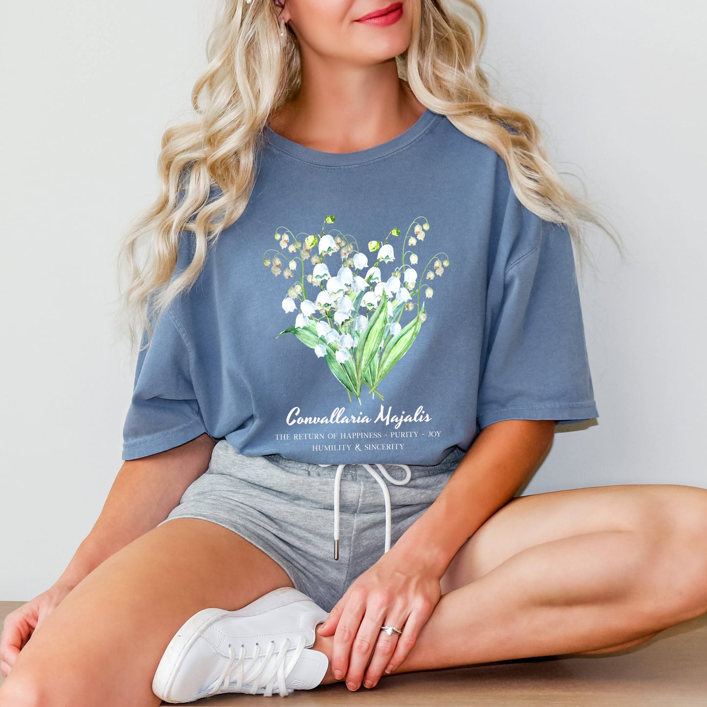 Woman wearing a blue Blue Jean garment-dyed Lily of the Valley botanical shirt – Crossroads Dandelion