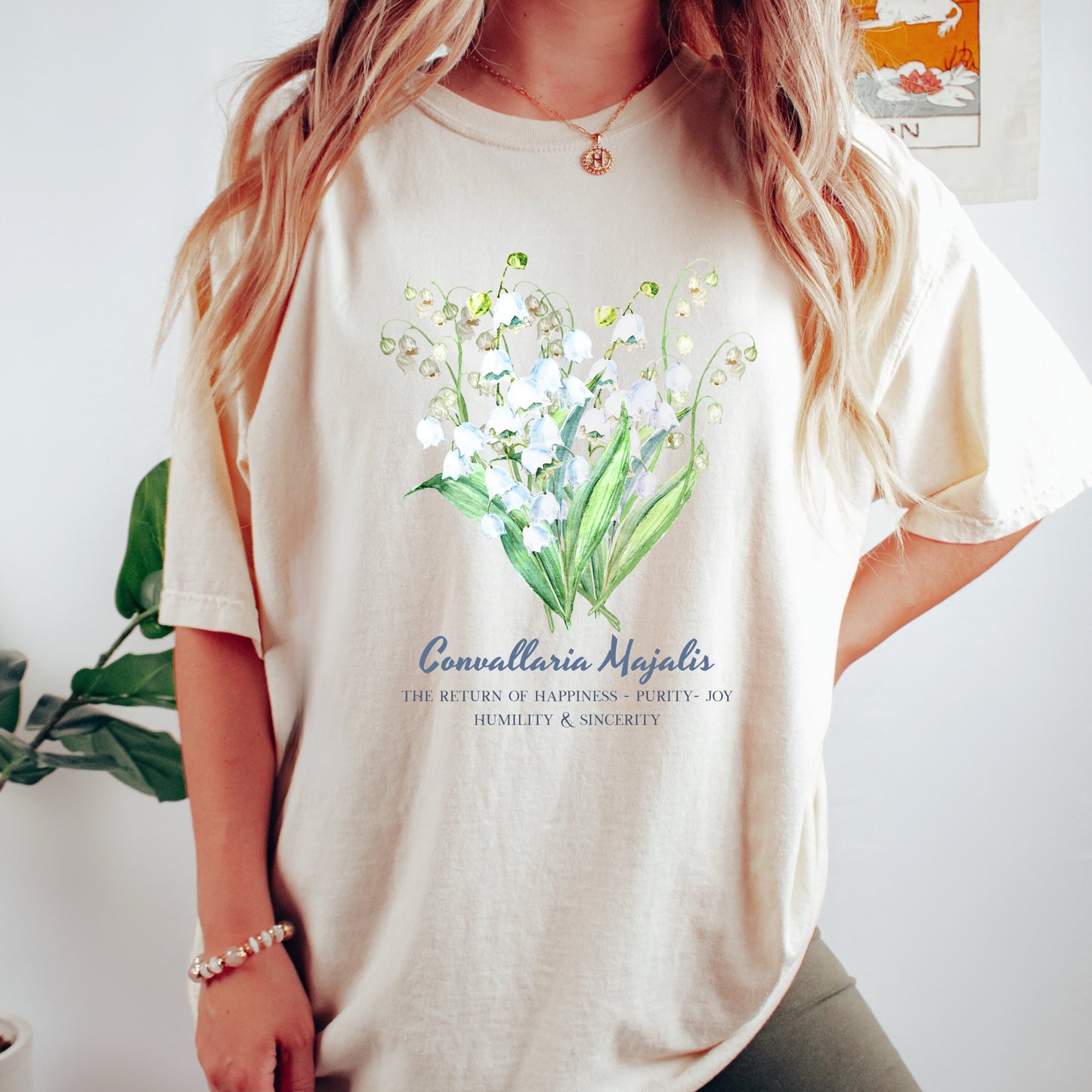 Woman wearing an Ivory botanical art Lily of the Valley May birthday gift tee – Crossroads Dandelion

