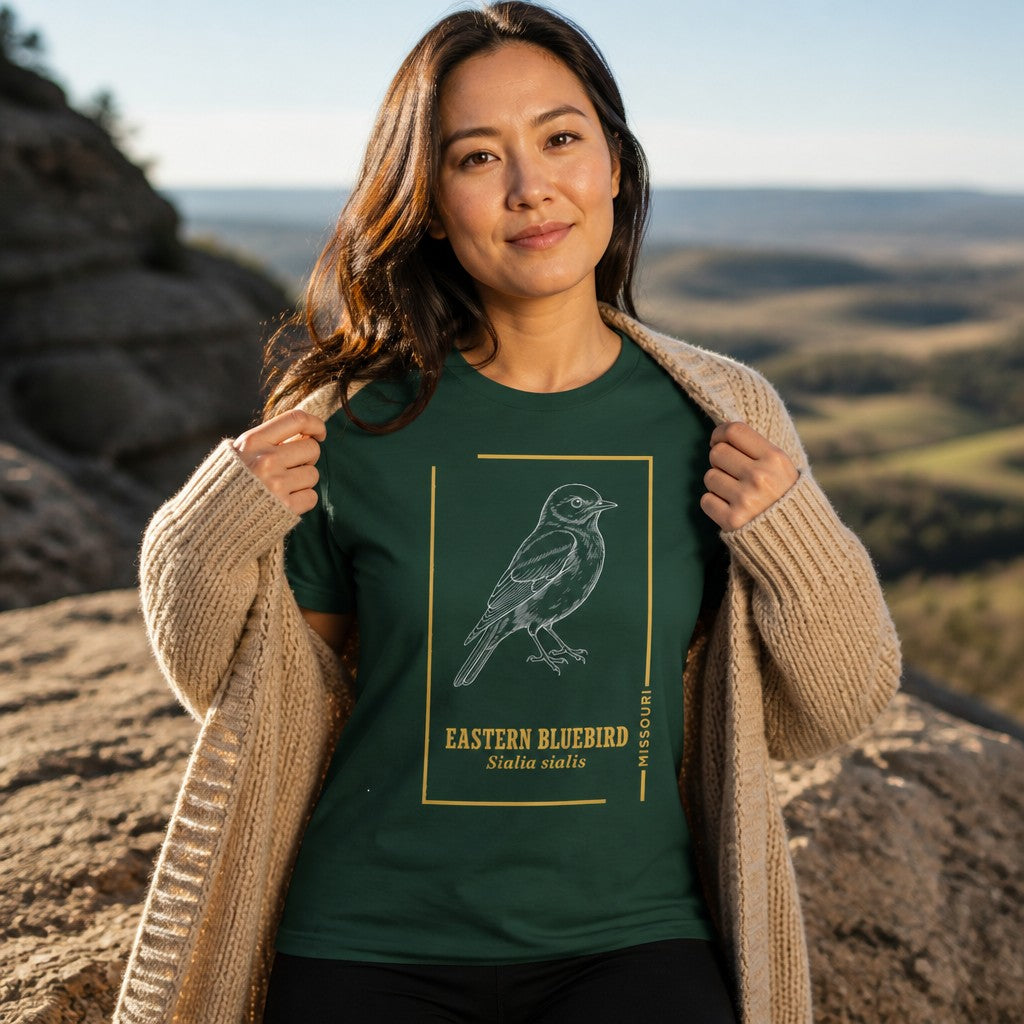 Woman wearing a forest green t-shirt featuring a line art eastern bluebird design, ideal for birdwatchers and nature lovers, photographed outdoors on a scenic vista, women's apparel, by Crossroads Dandelion
