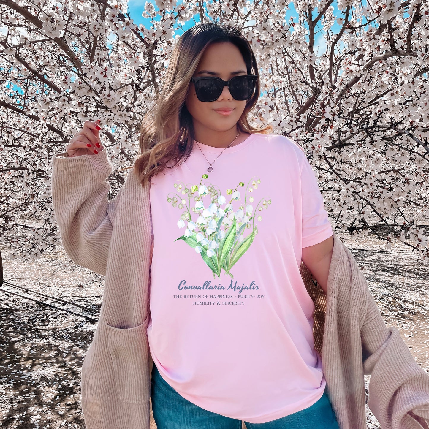 A woman wearing a Blossom pink cottagecore Lily of the Valley May birth month tee – Crossroads Dandelion