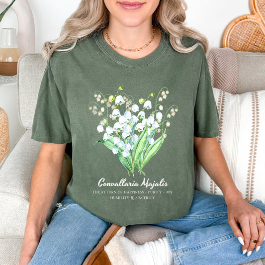 Woman wearing a Moss green cottagecore Lily of the Valley birth flower shirt – Crossroads Dandelion