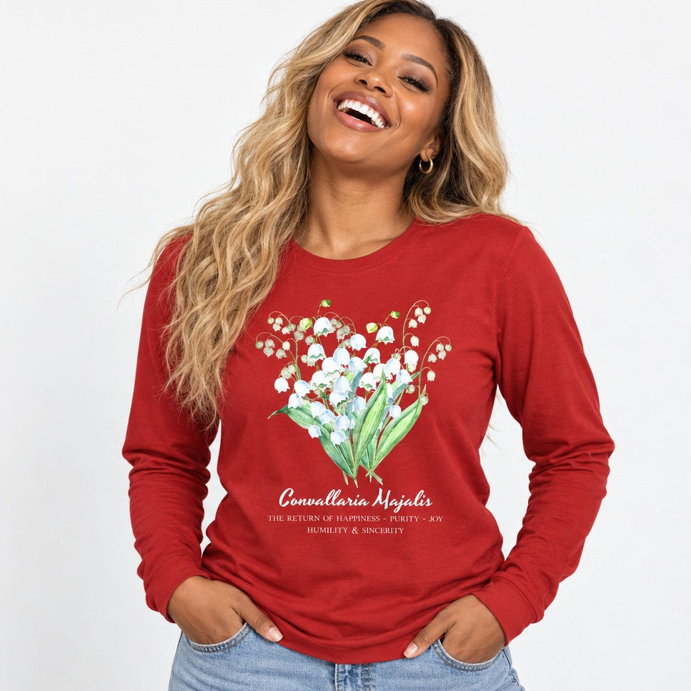 Woman in red Bella Canvas 3501 long sleeve shirt featuring a vintage watercolor lily of the valley botanical bouquet, cottagecore floral illustration, casual studio setting, perfect for women who love nature-inspired and cottage garden style, by Crossroads Dandelion