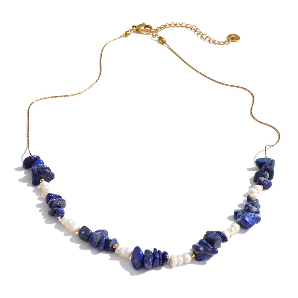 Lapis lazuli chip and pearl necklace on a gold-plated chain, laid flat on white