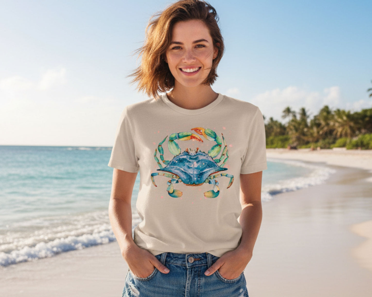 Soft cream coastal tee featuring whimsical watercolor blue crab with an ocean background