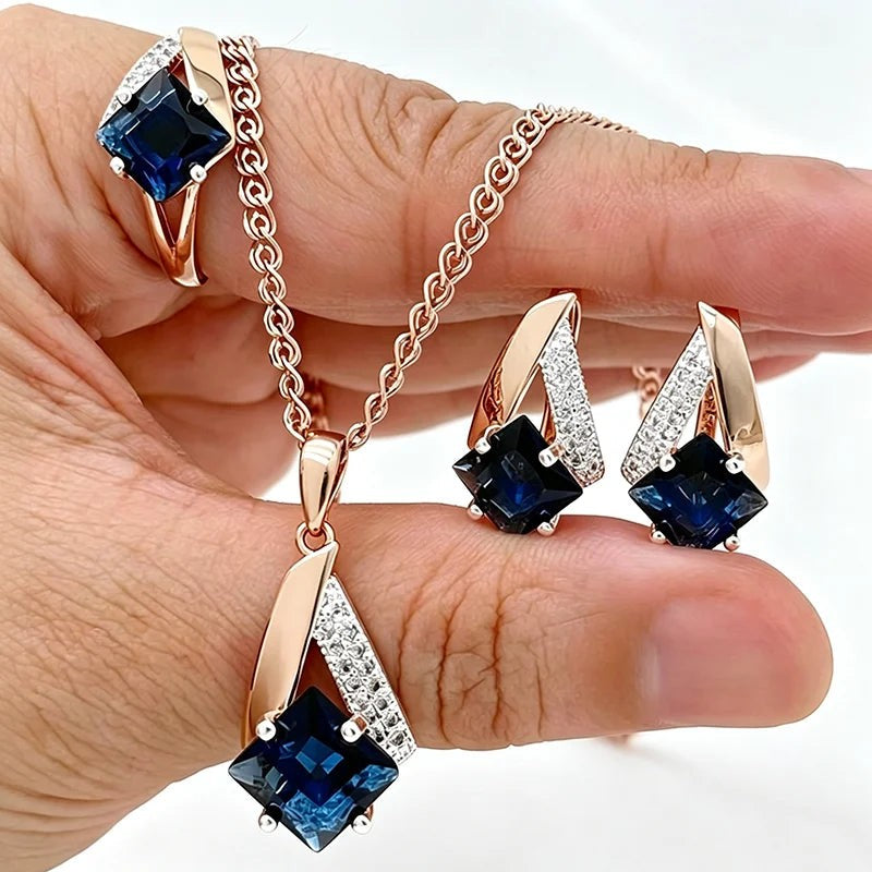 Ocean blue square pendant necklace, earrings and ring in two-tone rose gold held in a hand