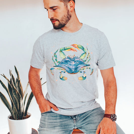 Man wearing an athletic heather ocean lover shirt featuring watercolor blue crab artwork, by Crossroads Dandelion 