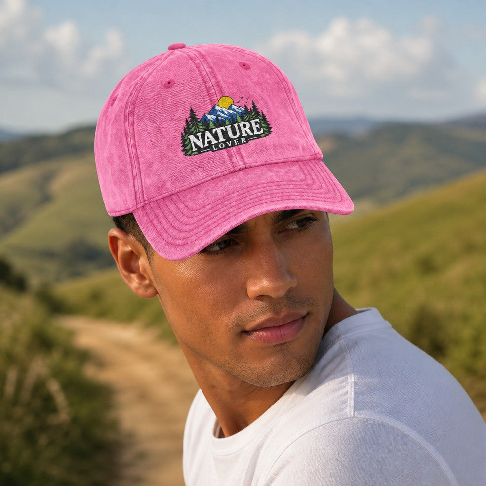 Man wearing a pink baseball cap with a retro forest and mountain 'Nature Lover' graphic, hiking on a scenic outdoor trail, perfect for outdoor enthusiasts and hikers, by Crossroads Dandelion